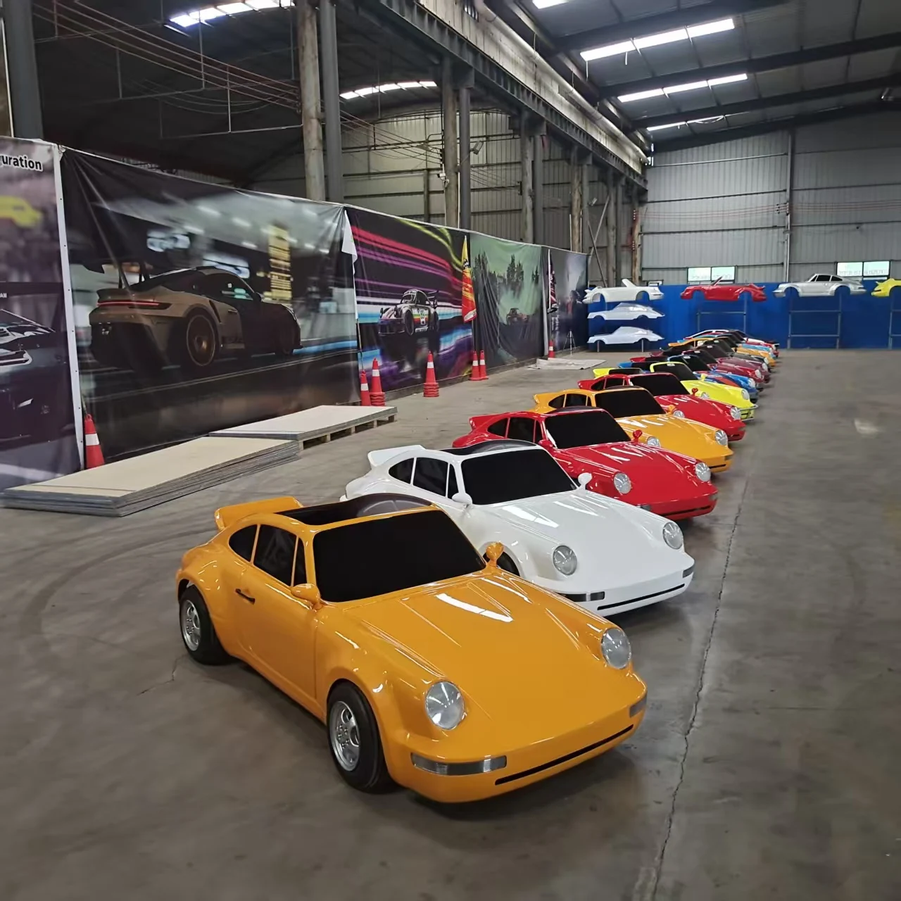 Orange, white and red sports-car-style adult drift go karts lined up in a workshop