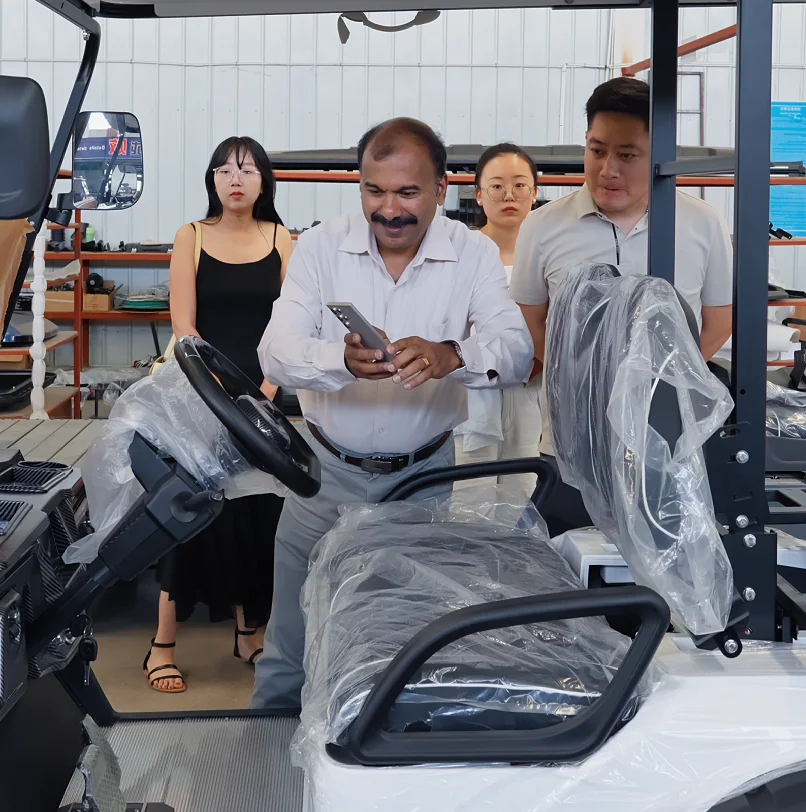 International customers reviewing a passenger golf cart at the factory